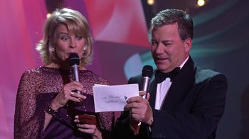 Movie still from “Miss Congeniality” (2000), directed by Donald Petrie – A man and a woman holding microphones in front of each other; Medium shot, Low angle