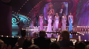 Movie still from “Miss Congeniality” (2000), directed by Donald Petrie – A group of women standing on a stage in front of an audience; Wide shot, Low angle