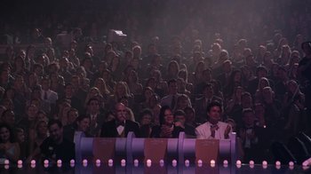 Movie still from “Miss Congeniality” (2000), directed by Donald Petrie – A group of people sitting in front of a large audience; Wide shot, High angle
