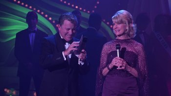 Movie still from “Miss Congeniality” (2000), directed by Donald Petrie – A man and a woman are holding a cell phone; Medium shot, High angle