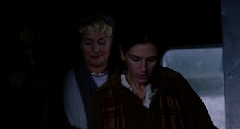 Two women are standing next to each other in the dark