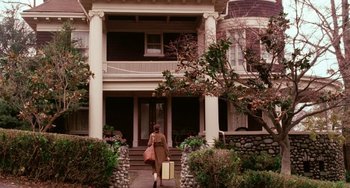 Movie still from “Mona Lisa Smile” (2003), directed by Mike Newell – A woman walking down the sidewalk of a house; Wide shot, Low angle