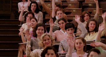 Movie still from “Mona Lisa Smile” (2003), directed by Mike Newell – A group of people sitting in a lecture hall with their hands up; Medium shot, High angle
