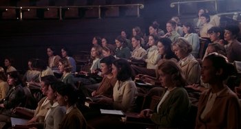 Movie still from “Mona Lisa Smile” (2003), directed by Mike Newell – A group of people sitting in a theater; Wide shot, High angle