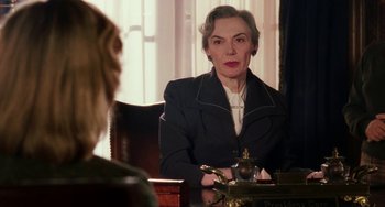 Movie still from “Mona Lisa Smile” (2003), directed by Mike Newell – An older woman sitting in front of a tea pot; Medium shot, Over the shoulder angle