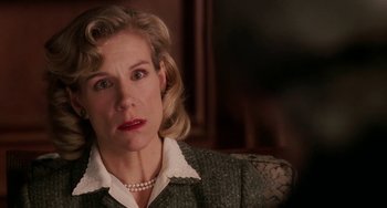 Movie still from “Mona Lisa Smile” (2003), directed by Mike Newell – An older woman wearing a green jacket and a white blouse; Close Up shot, Over the shoulder angle