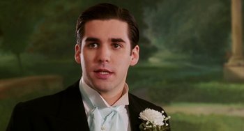 Movie still from “Mona Lisa Smile” (2003), directed by Mike Newell – A man in a tuxedo with a white flower in his hand; Close Up shot, Over the shoulder angle