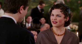 Movie still from “Mona Lisa Smile” (2003), directed by Mike Newell – A woman in a brown dress talking to a man in a brown suit; Close Up shot, Over the shoulder angle