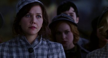 Movie still from “Mona Lisa Smile” (2003), directed by Mike Newell – A woman wearing a hat and a plaid jacket; Close Up shot, Over the shoulder angle