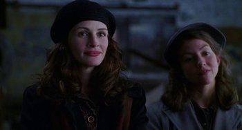 Movie still from “Mona Lisa Smile” (2003), directed by Mike Newell – A woman in a black hat is looking at the camera; Close Up shot, Over the shoulder angle