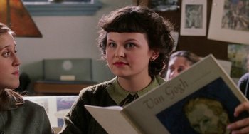 Movie still from “Mona Lisa Smile” (2003), directed by Mike Newell – A woman sitting in front of an open book; Close Up shot, High angle