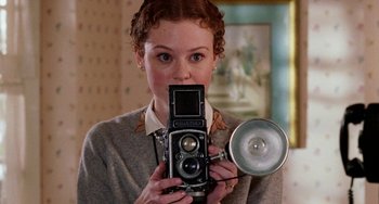 Movie still from “Mona Lisa Smile” (2003), directed by Mike Newell – A woman taking a picture of herself with an old camera; Close Up shot, High angle