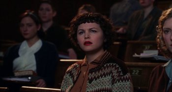 Movie still from “Mona Lisa Smile” (2003), directed by Mike Newell – A woman in a crowd of people sitting in a room; Medium shot, High angle