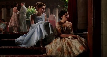 Movie still from “Mona Lisa Smile” (2003), directed by Mike Newell – Two young women sitting next to each other on a bench; Medium shot, Over the shoulder angle