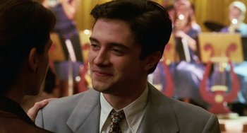 Movie still from “Mona Lisa Smile” (2003), directed by Mike Newell – A man wearing a suit and tie smiling; Close Up shot, High angle