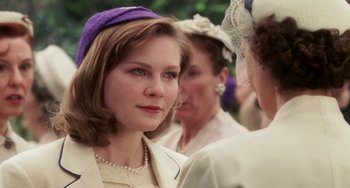 Movie still from “Mona Lisa Smile” (2003), directed by Mike Newell – A woman in a purple hat and a white jacket; Close Up shot, Over the shoulder angle