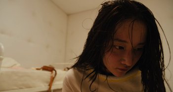 Movie still from “Mona Lisa and the Blood Moon” (2021), directed by Ana Lily Amirpour – A young girl with wet hair looking at the camera; Close Up shot, High angle