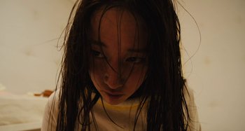 Movie still from “Mona Lisa and the Blood Moon” (2021), directed by Ana Lily Amirpour – A woman with long black hair is looking at the camera; Close Up shot, High angle