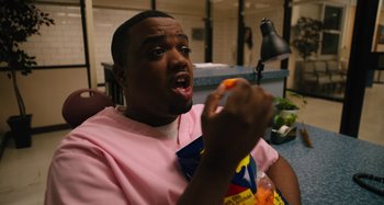 Movie still from “Mona Lisa and the Blood Moon” (2021), directed by Ana Lily Amirpour – A man is eating something while sitting at a table; Close Up shot, High angle