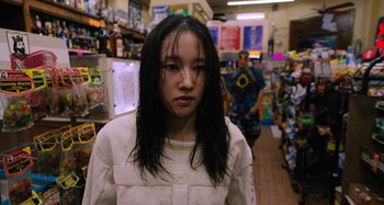 Movie still from “Mona Lisa and the Blood Moon” (2021), directed by Ana Lily Amirpour – A woman with long black hair standing in a store; Close Up shot, Over the shoulder angle
