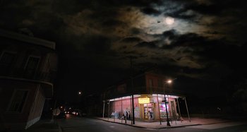 Movie still from “Mona Lisa and the Blood Moon” (2021), directed by Ana Lily Amirpour – People are standing on the side of the street at night under a full moon; Extreme Wide shot, Low angle