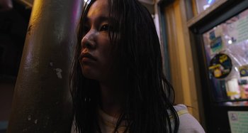 Movie still from “Mona Lisa and the Blood Moon” (2021), directed by Ana Lily Amirpour – A woman with long black hair looking into the distance; Close Up shot, Low angle