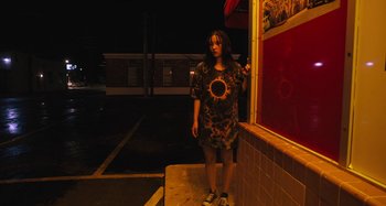 Movie still from “Mona Lisa and the Blood Moon” (2021), directed by Ana Lily Amirpour – A woman standing in front of a building at night; Medium shot, Low angle