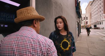 Movie still from “Mona Lisa and the Blood Moon” (2021), directed by Ana Lily Amirpour – A young woman standing next to an older man on a sidewalk; Medium shot, Over the shoulder angle