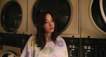 Movie still from “Mona Lisa and the Blood Moon” (2021), directed by Ana Lily Amirpour – A young woman standing in front of a washing machine; Medium shot, Low angle