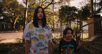 Movie still from “Mona Lisa and the Blood Moon” (2021), directed by Ana Lily Amirpour – Two young people standing in front of a tree; Medium shot, Low angle