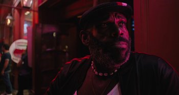 Movie still from “Mona Lisa and the Blood Moon” (2021), directed by Ana Lily Amirpour – A man with a beard wearing a hat and a jacket; Close Up shot, Low angle