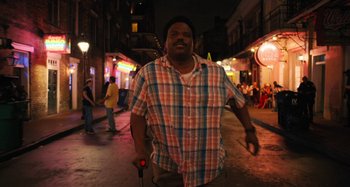 Movie still from “Mona Lisa and the Blood Moon” (2021), directed by Ana Lily Amirpour – A man walking down a street at night; Medium shot, Low angle