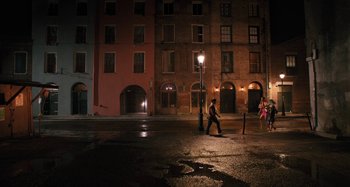 Movie still from “Mona Lisa and the Blood Moon” (2021), directed by Ana Lily Amirpour – A man walking across a street at night; Extreme Wide shot, High angle
