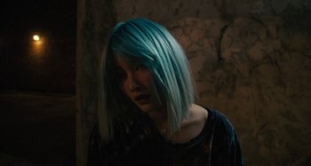 Movie still from “Mona Lisa and the Blood Moon” (2021), directed by Ana Lily Amirpour – A woman with blue hair is standing in a dark room; Close Up shot, High angle