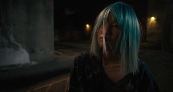 Movie still from “Mona Lisa and the Blood Moon” (2021), directed by Ana Lily Amirpour – A person with blue hair standing in the dark; Close Up shot, Over the shoulder angle