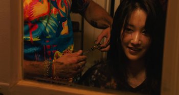 Movie still from “Mona Lisa and the Blood Moon” (2021), directed by Ana Lily Amirpour – A woman getting her hair cut by a barber; Close Up shot, Over the shoulder angle