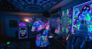 Movie still from “Mona Lisa and the Blood Moon” (2021), directed by Ana Lily Amirpour – A man standing in front of a wall covered in glow in the dark paint; Wide shot, Low angle