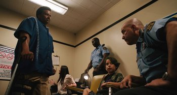 Movie still from “Mona Lisa and the Blood Moon” (2021), directed by Ana Lily Amirpour – A group of people sitting in a room; Medium shot, Low angle