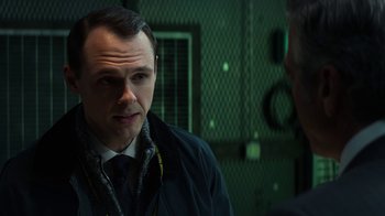 Movie still from “Money Monster” (2016), directed by Jodie Foster – A man wearing a suit and tie talking to another man wearing a suit and tie; Close Up shot, Over the shoulder angle