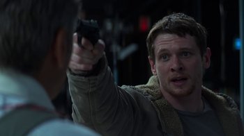 Movie still from “Money Monster” (2016), directed by Jodie Foster – A man holding a gun in his right hand; Close Up shot, Over the shoulder angle