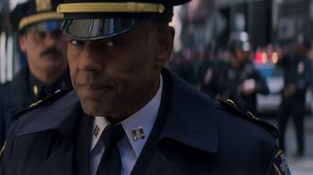 Movie still from “Money Monster” (2016), directed by Jodie Foster – A person wearing a uniform; Close Up shot, Over the shoulder angle