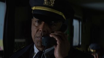 Movie still from “Money Monster” (2016), directed by Jodie Foster – A man in a uniform talking on a phone; Close Up shot, Low angle