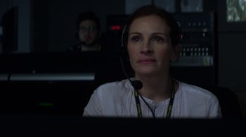 Movie still from “Money Monster” (2016), directed by Jodie Foster – A woman wearing a headset in front of a computer screen; Close Up shot, Over the shoulder angle