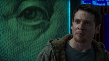 Movie still from “Money Monster” (2016), directed by Jodie Foster – A man standing in front of an image of an eye; Close Up shot, Over the shoulder angle
