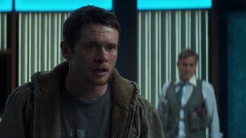 Movie still from “Money Monster” (2016), directed by Jodie Foster – A man standing next to another man in a room; Close Up shot, Over the shoulder angle