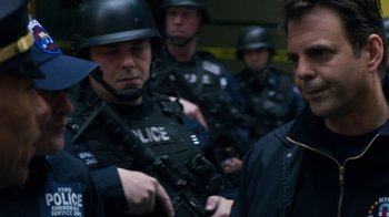 Movie still from “Money Monster” (2016), directed by Jodie Foster – A group of men in police uniforms and helmets; Close Up shot, Over the shoulder angle