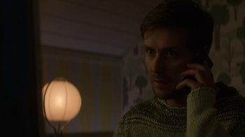 Movie still from “Money Monster” (2016), directed by Jodie Foster – A man is talking on a cell phone in the dark; Close Up shot, Low angle