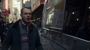 Movie still from “Money Monster” (2016), directed by Jodie Foster – A man standing on the side of the street in front of a bus; Medium shot, Over the shoulder angle