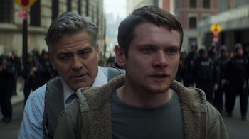 Movie still from “Money Monster” (2016), directed by Jodie Foster – A man and a man in a crowd of onlookers; Close Up shot, Over the shoulder angle