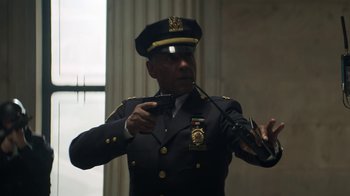 Movie still from “Money Monster” (2016), directed by Jodie Foster – A man in a police uniform holding a gun; Medium shot, Low angle